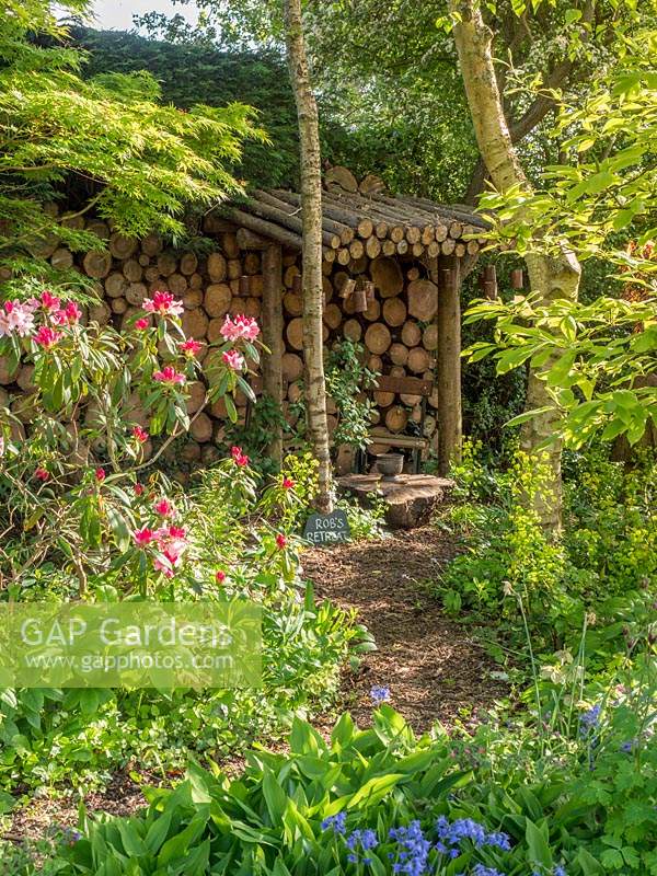 A wood chip path leads to a log store which blends into the garden and becomes a garden feature in its own right.