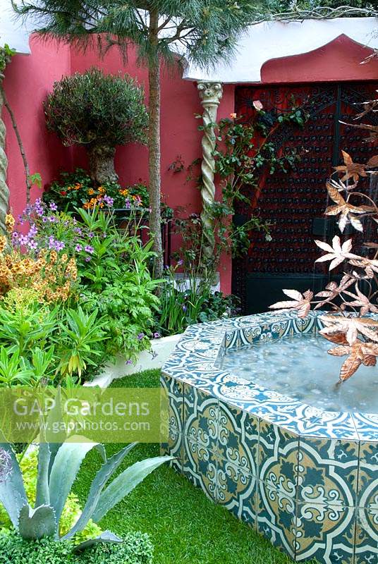 Spanish garden with decorative pool, herbaceous planting and copper feature - RHS Chelsea Flower Show