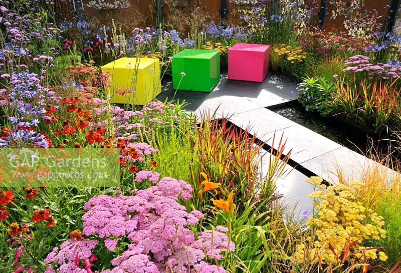 Colour Box garden, RHS Hampton Court Palace Flower Show, 2017.  Colourful perennial borders with limestone path and plastic cubed seating.