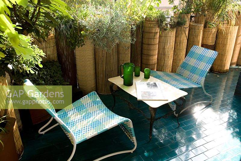 Table and chairs on blue tiled terrace 