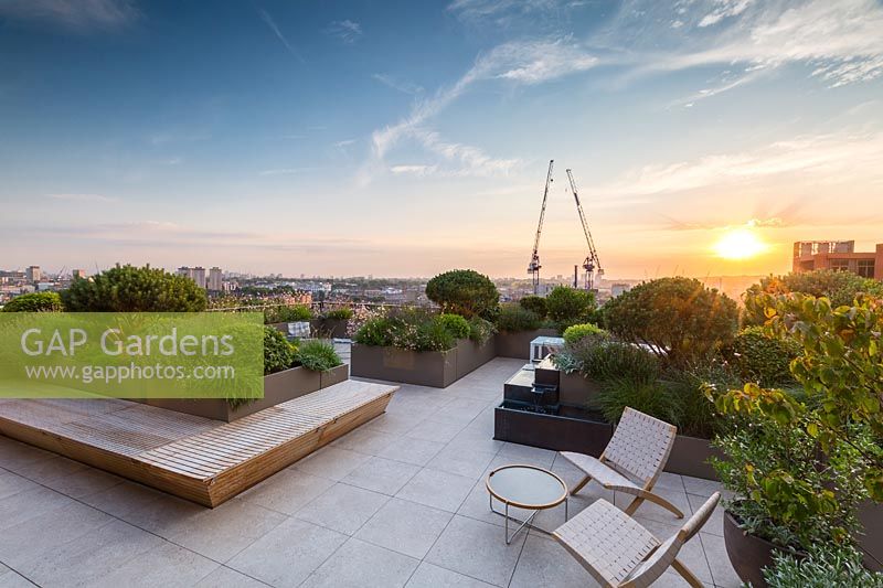 Sunset viewed from Roof Terrace to London skyline at sunset with paved seating area
