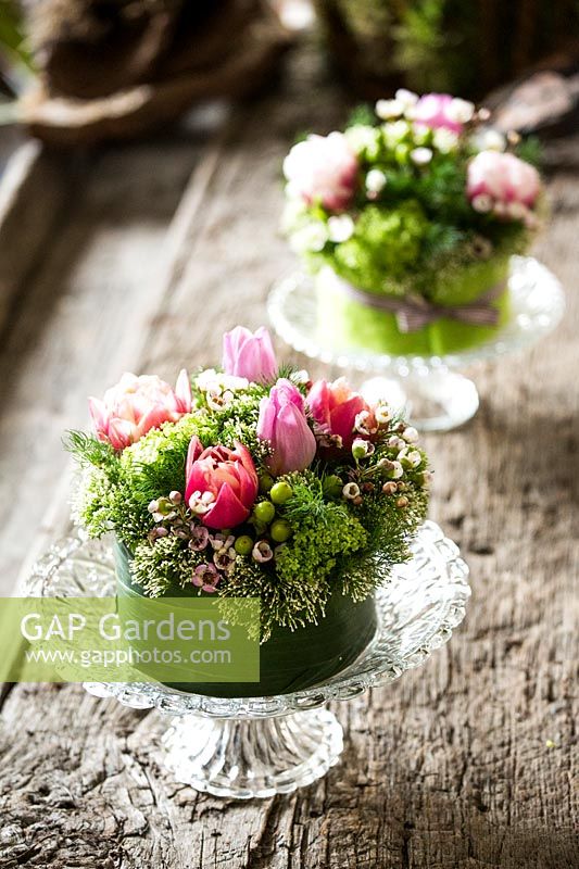 Small floral arrangements made with tulips, viburnum and wax flower. 

