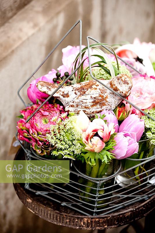 Metal basket with mixed buttercups, sweet peas and roses
