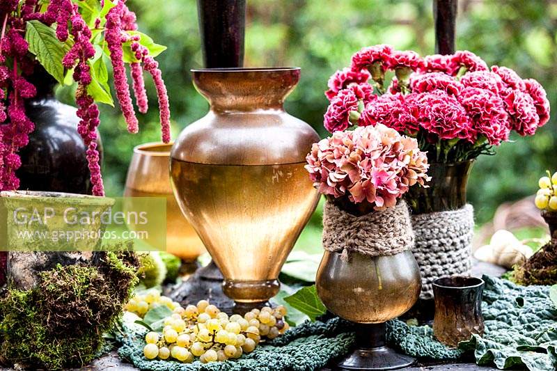 Autumn table decorated with hydrangeas, carnations, amaranth, grapes, savoy cabbage