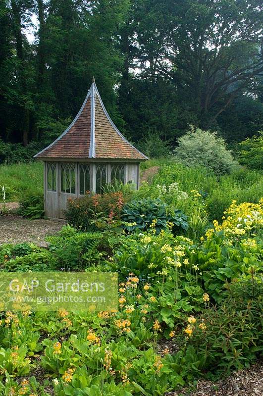 Summerhouse in bog garden of Primula and Hosta 