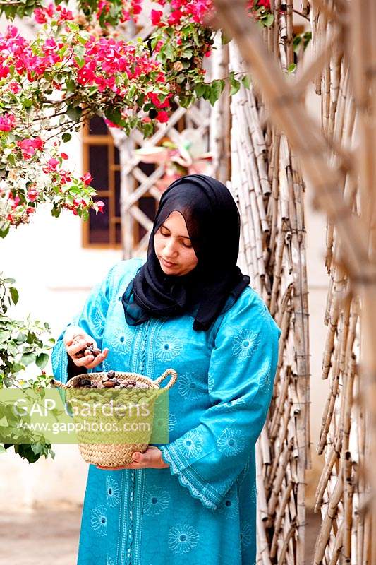 Woman holding a basket of harvested Argan nuts