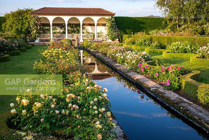 View across rill with rose beds on either side, serpentine edging, lawn and loggia in The Renaissance Garden