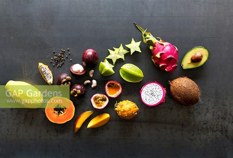Selection of tropical fruits, some whole others cut open: Mango, Coconut, Papaya, Avocado, Pitaya, Mangosteen, Star Fruit, Passion Fruit