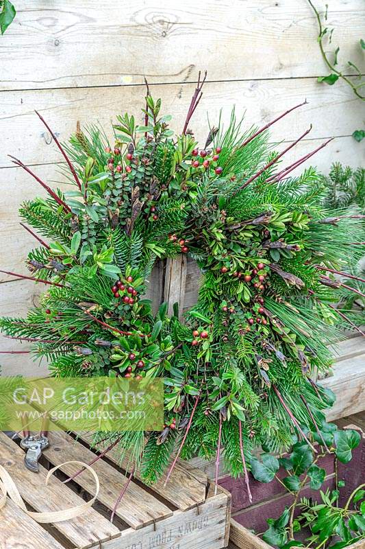 Finished wreath on workbench made with winter foliage and cuttings