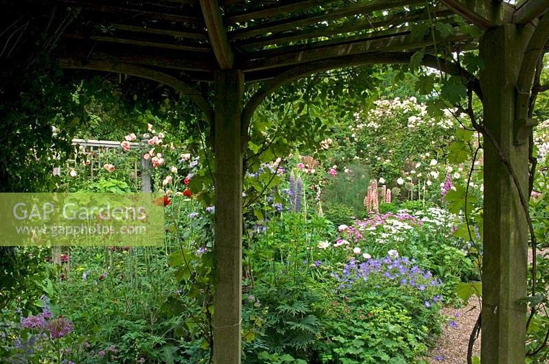 View from inside wooden gazebo to cottage garden border