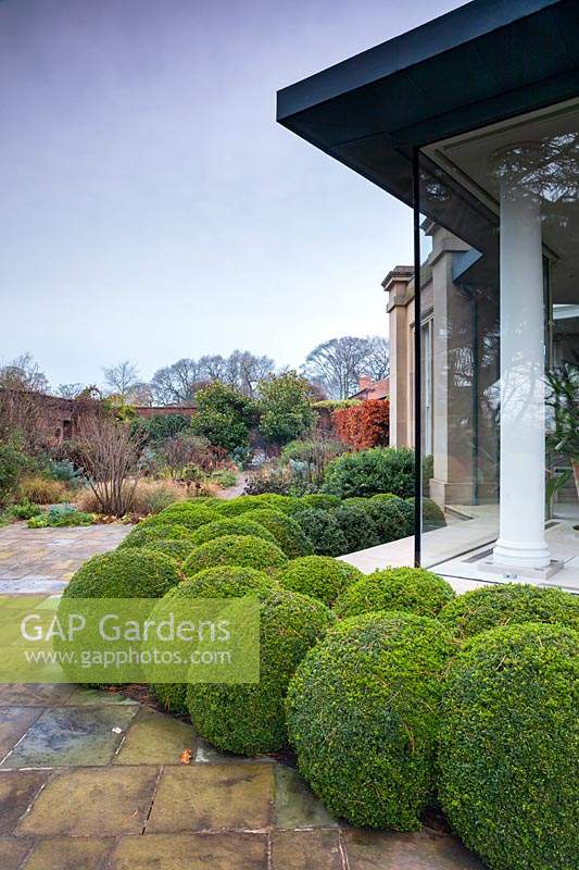 Topiary balls in courtyard of walled garden