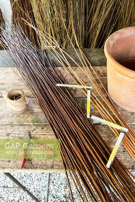 Stems of willow and tools to make woven plant cone supports. 