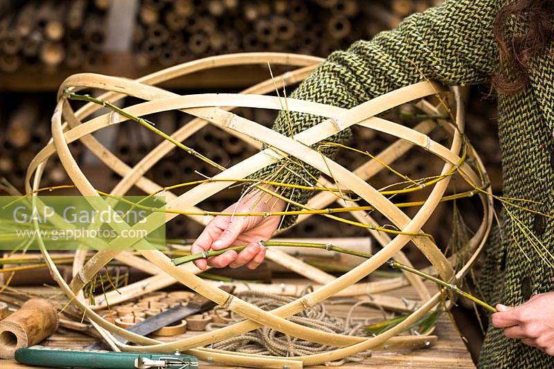 Hand weaving strips of Bamboo to create a lampshade