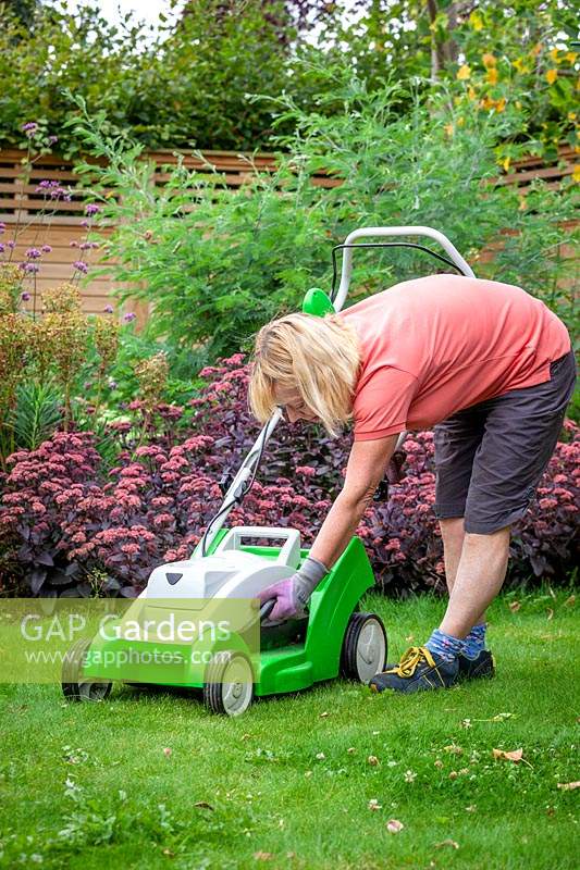 Raising the height of lawnmower blades before cutting a lawn during a dry spell