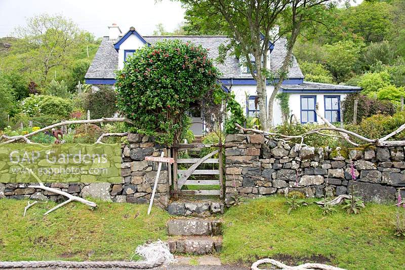 Stone wall and rustic wooden gate at entrance to front garden 