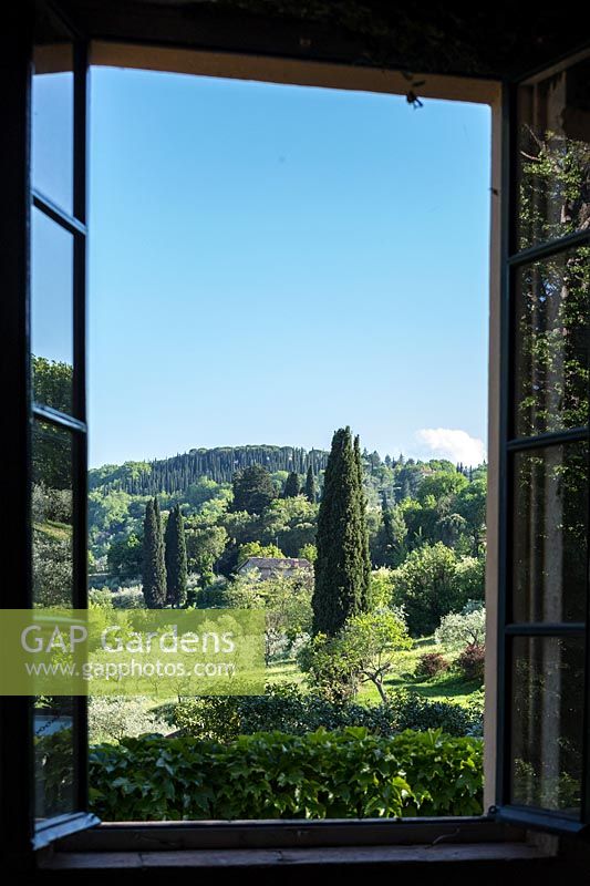 The view through a window out onto Umbrian landscape with Cupressus sempervirens - Cypress - trees and Olea europae - Olive - trees