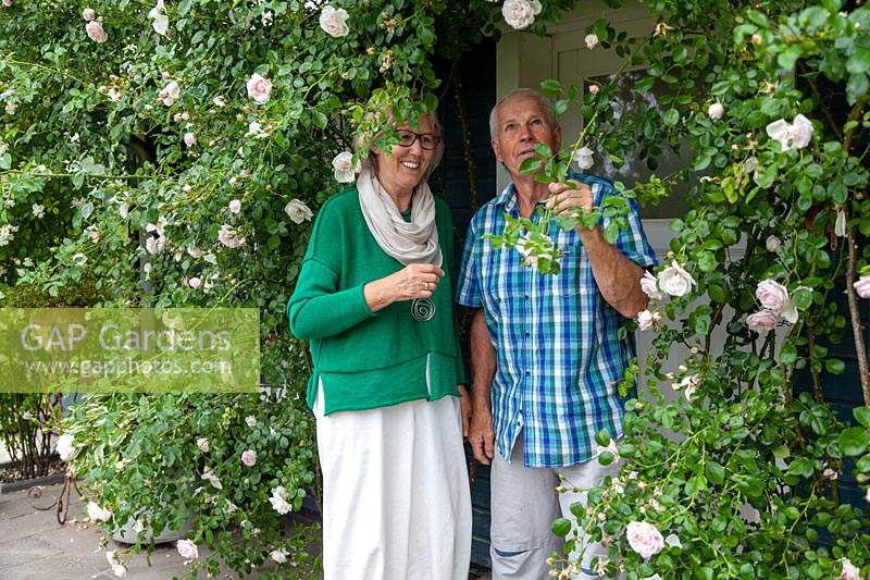 Couple standing by Rosa - Rose - climbers