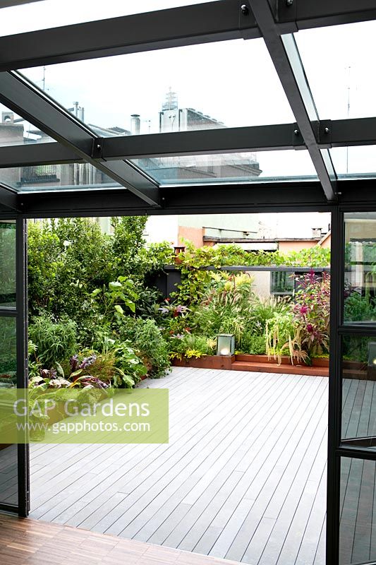 View from conservatory to terrace with planted corten containers 
