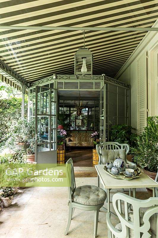 Two shady verandas connect the outdoor area dominated with pots of purple flowers preferred by Pierre Berge