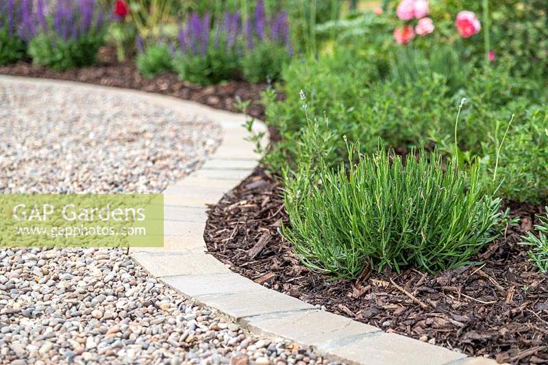 Curved gravel garden path with with 'Scottish Pebbles' gravel and edged with sandstone setts in 'Castle Grey'