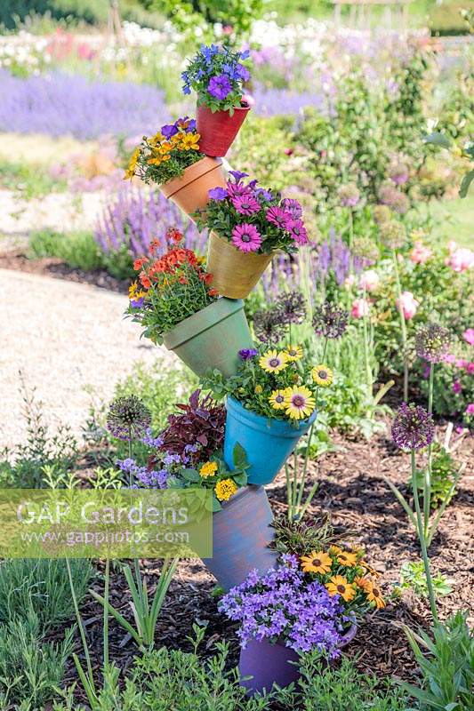 Rainbow pot tower adding height and colour to a flower bed