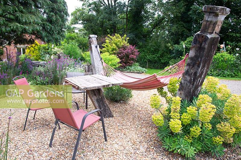 A hammock in a gravel garden with table and chairs