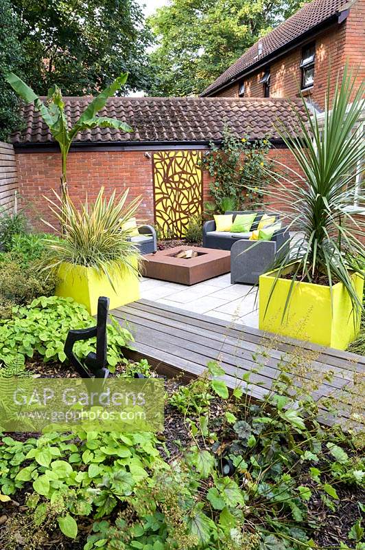 Small Modern Garden with sofa and armchairs around a fire pit