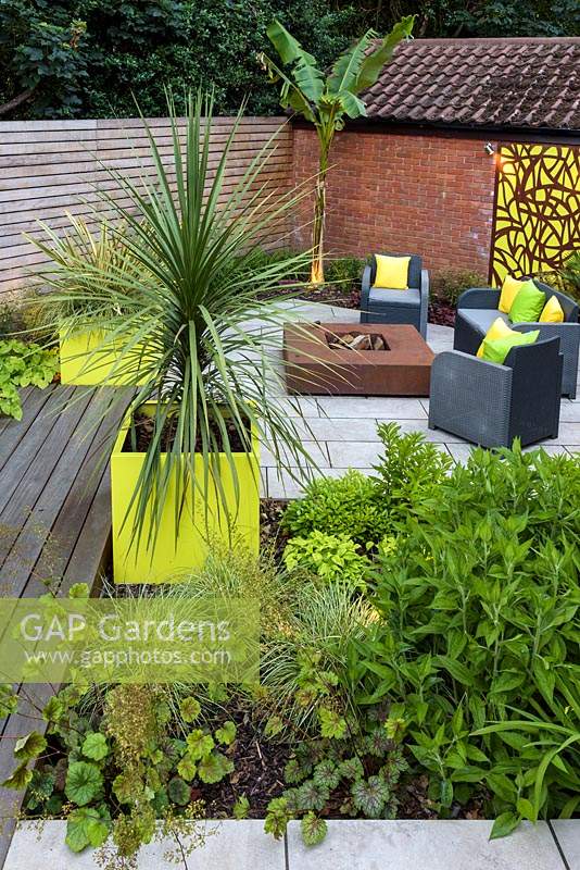 Small Modern Garden with sofa and armchairs around fire pit