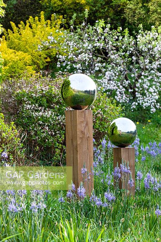Stainless steel globes on wooden columns.