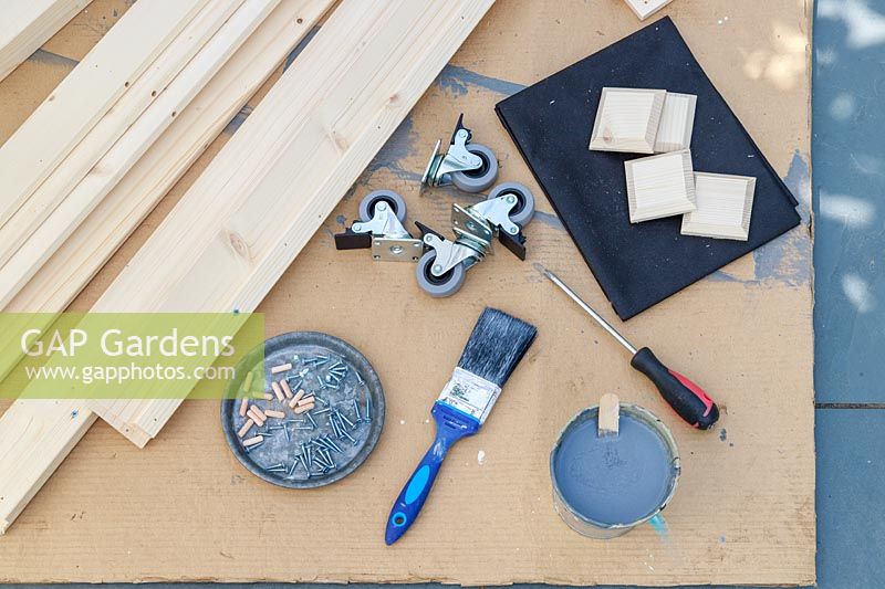 Materials and tools required to assemble a kit form raised planter on casters