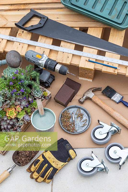 Tools and materials for creating a succulent plant pallet table on castors. 