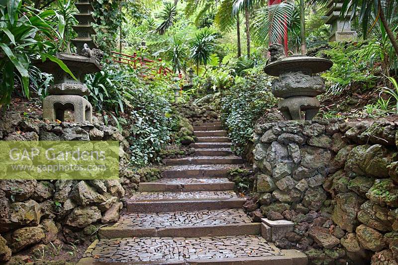 Steps up between two retaining walls, oriental objects on walls