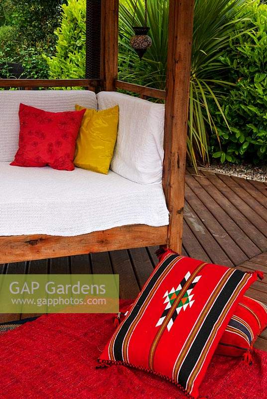 Seat and rug with cushions on garden decking - Open Gardens Day, Bures, Suffolk