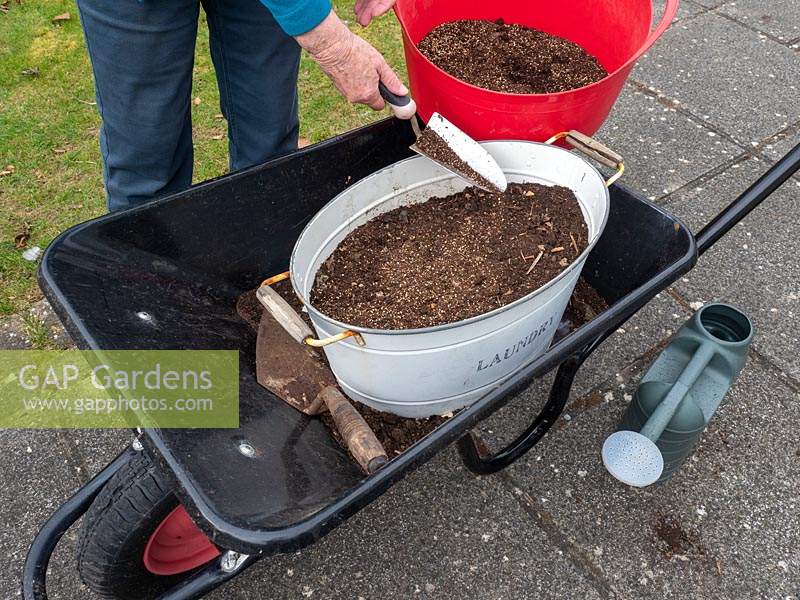 Use old containers to plant a wild flower garden.  Covering newly sewn seeds with compost 