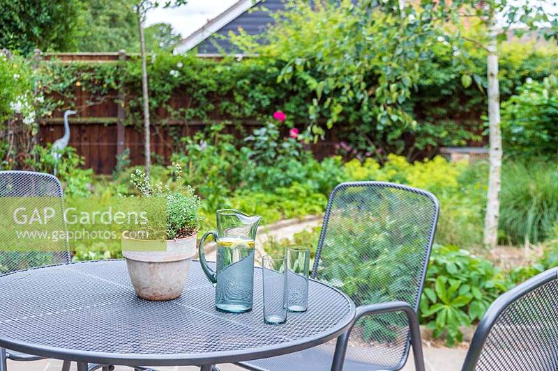 View of suburban garden from metal dining table and chairs