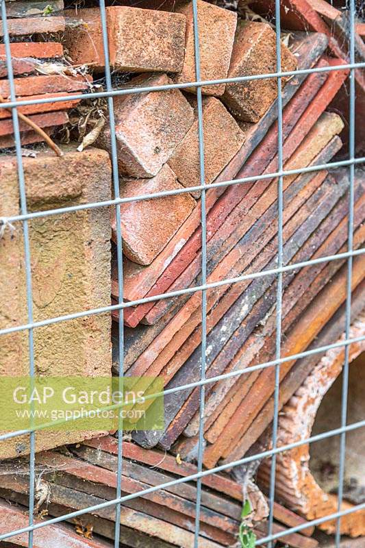 Close up detail of gabion cage filled with roof tiles, pipes and bricks