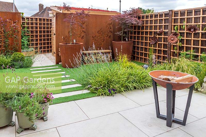 Suburban garden with corten steel screen screens, artificial grass and paving