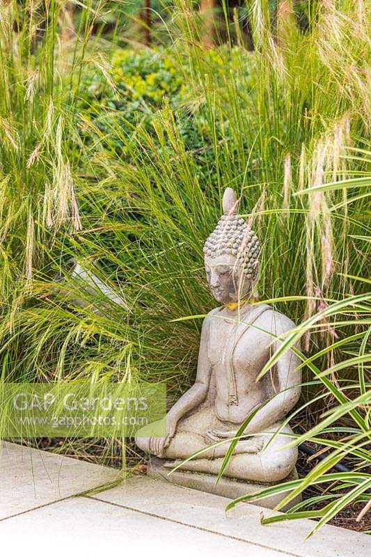 Oriental sculpture backed by ornamental grasses