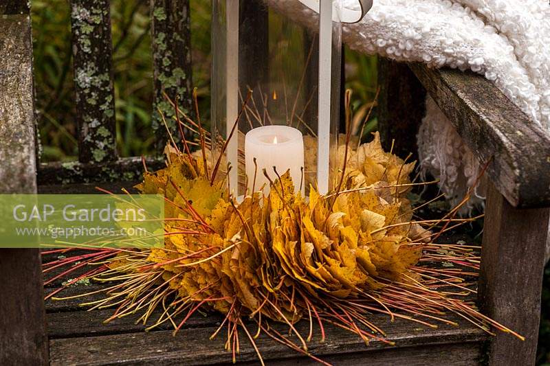 Autumn leaf wreath with lantern on a garden chair - November
