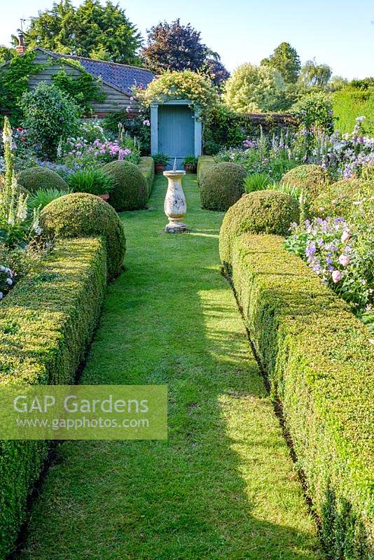 The Secret Garden with Sundial and clipped Buxus - Box hedges and balls. 