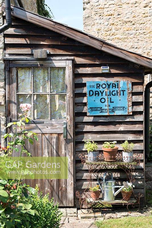 Wooden leanto shed with vintage metal sign