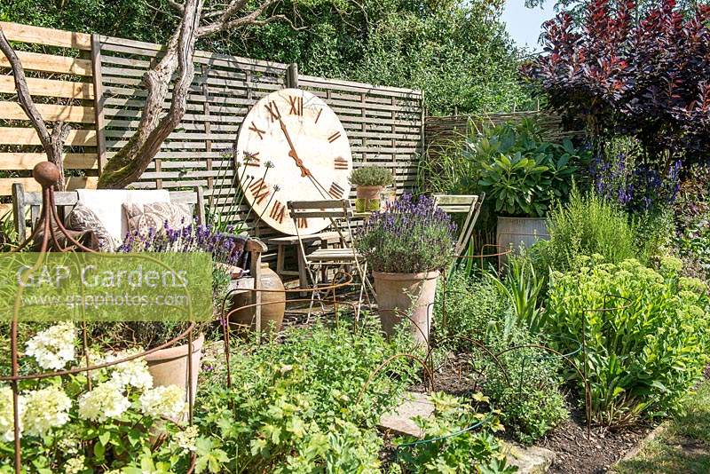Seating area with giant wall clock and pots with lavandula