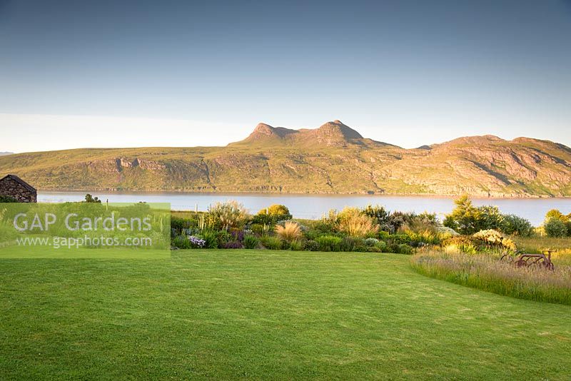 Private garden on Little Loch Broom, Wester Ross planted with many South African plants, with view of Beinn Ghobhlach beyond. 
