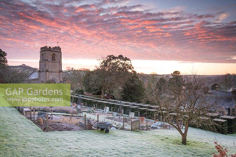 Formal kitchen garden on a frosty January morning at the Old Rectory, Netherbury with the backdrop of St Mary's Church.