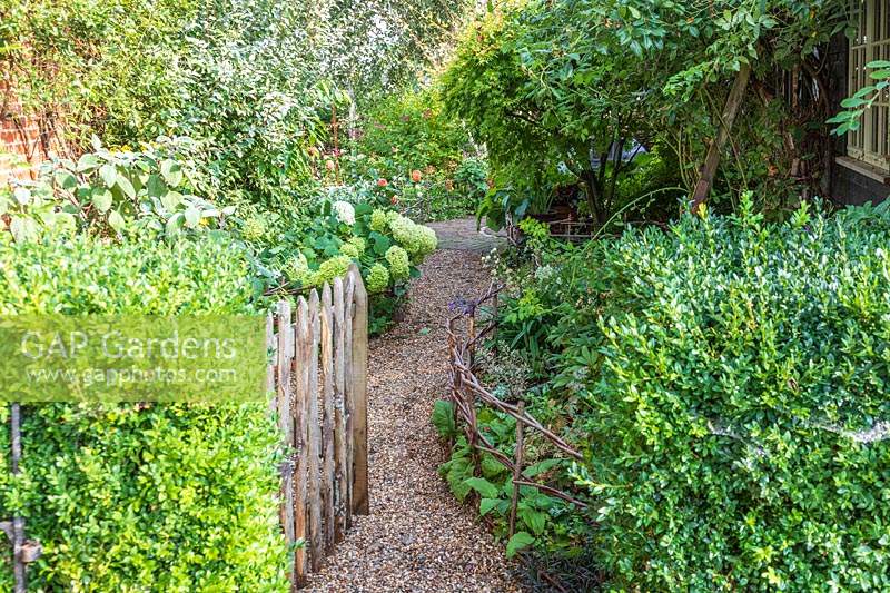 Rustic wooden side gate open to gravel path
