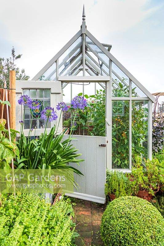 Wooden painted greenhouse with stable door half open 