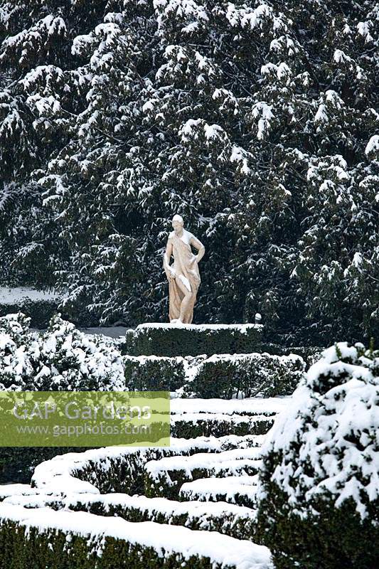 Statue with conifer backdrop with French-style parterre in foreground