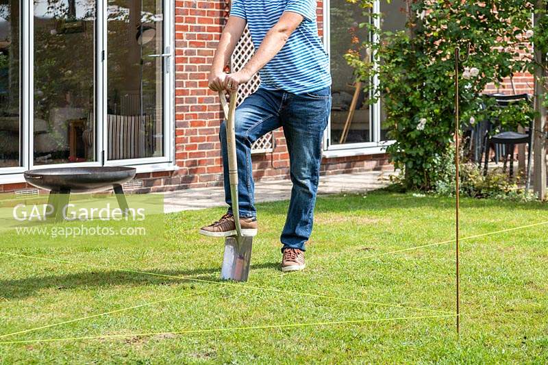 Man using a spade to remove turf where indicated by garden line