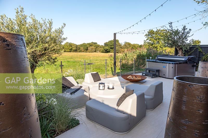 Modern lounge furniture with view to countryside and jacuzzi. 