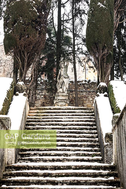 Stone steps leading to statue covered on snow